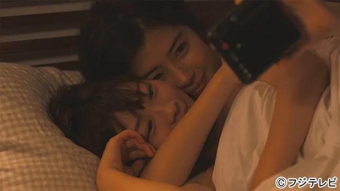 Pareja de mujeres abrazandose en la cama y sonriendo