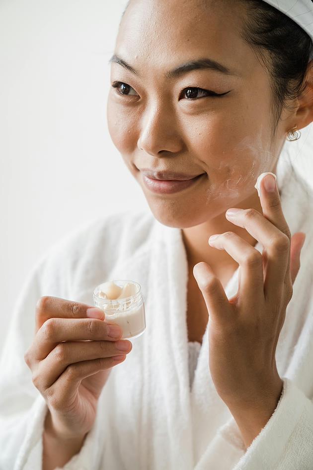 A woman moisturizing her face