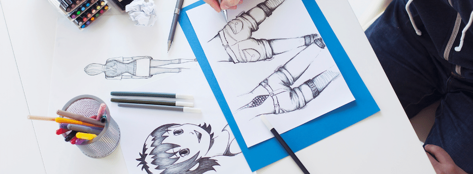 A close-up of a person drawing a manga character in a sketchbook.